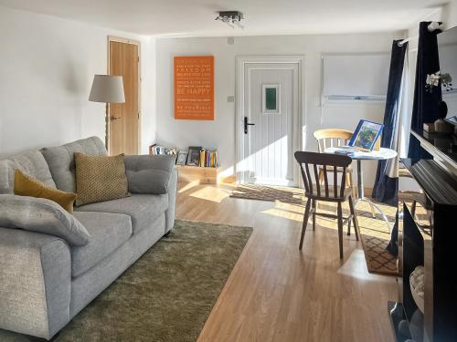 ein Wohnzimmer mit Sofa und einem Tisch mit Laptop in der Unterkunft Island Lodge - Uk46767 in Little Baddow