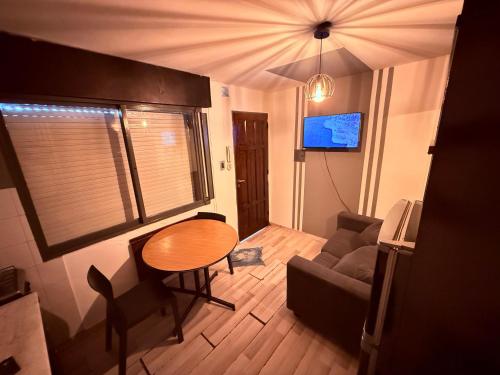 a small living room with a table and a couch at Bicentenario Alem in Villa María