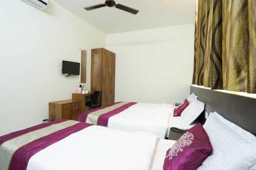 a hotel room with two beds and a ceiling fan at Hotel Prathiba Heritage in Trivandrum