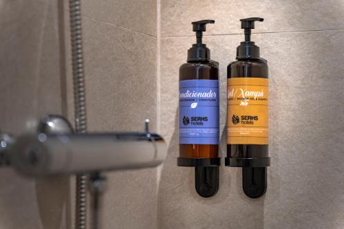two bottles of water are hanging on a wall at Hotel SERHS Del Port in Barcelona