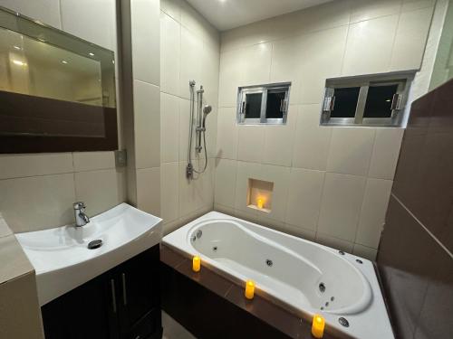 a bathroom with a bath tub and a sink at Casa Lujosa, Catemaco, Ubicación Céntrica in Catemaco