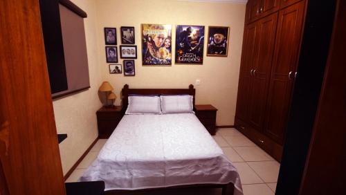 a bedroom with a bed with posters on the wall at Apartamento Centro São Carlos in São Carlos