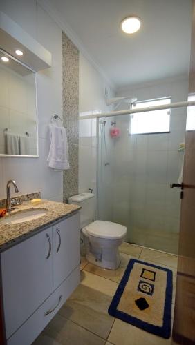 a bathroom with a toilet and a shower and a sink at Apartamento Centro São Carlos in São Carlos