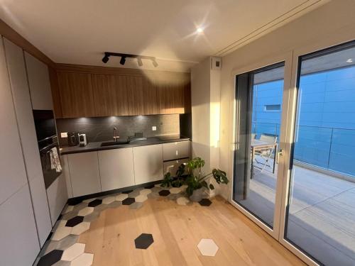 a kitchen with a sink and a counter top at Newly built 2-Bed Flat with parking in Pully in Pully