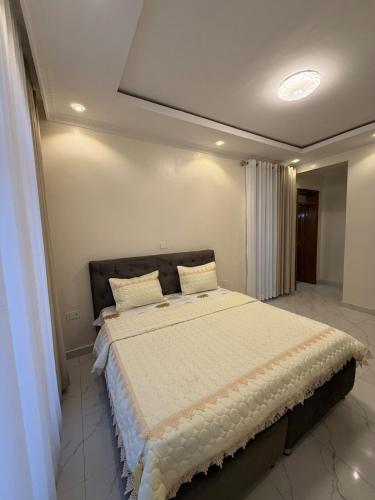 Un dormitorio con una cama grande en una habitación. en CityGlow Apartment, en Kigali