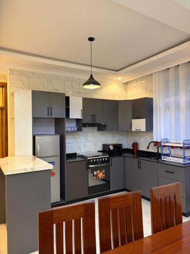 una cocina con estufa y una mesa con sillas en CityGlow Apartment, en Kigali