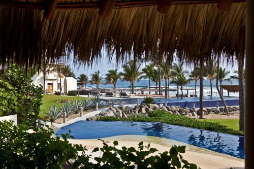 a view of a resort with a swimming pool and the beach at Stunning, Oceanfront Casa de Olas in Ixtapa-Zihuatanejo International