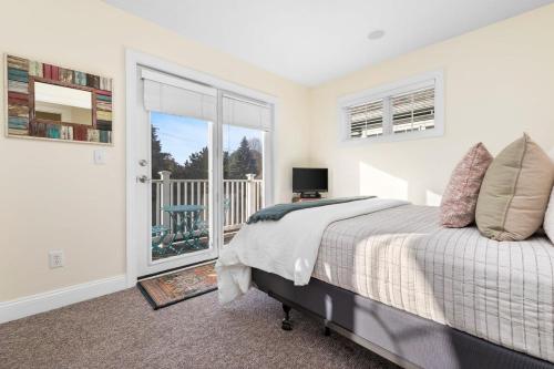 a bedroom with a bed and a balcony at Bay Park 32: Downtown Condo! in Traverse City