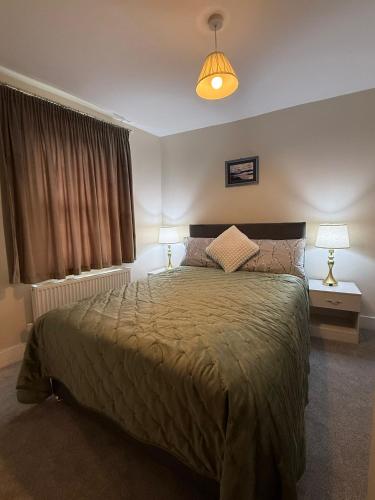 a bedroom with a bed with two lamps and a window at The Marsh Harrier B&B in Oxford