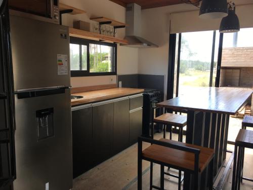 a kitchen with a refrigerator and a table with chairs at Pretas in Punta Del Diablo