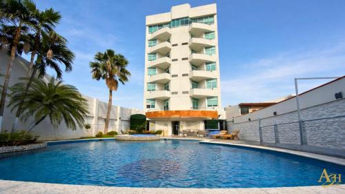 a swimming pool in front of a building at Angeles Suites & Hotel in Veracruz