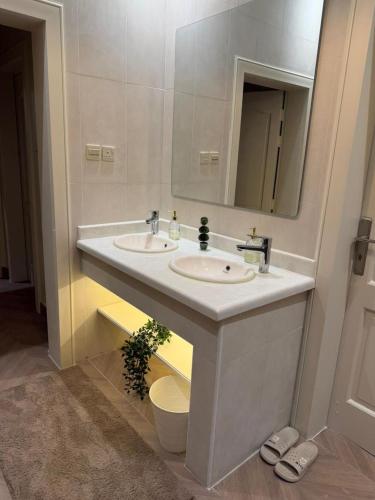 a bathroom with two sinks and a mirror at رحاب قريش in Al Masfalah