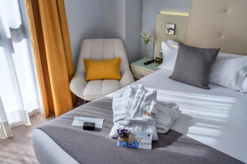 a hotel room with two beds and a chair at Hotel SERHS Del Port in Barcelona