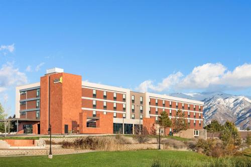 a university building with mountains in the background at Home2 Suites by Hilton Salt Lake City/Layton in Layton