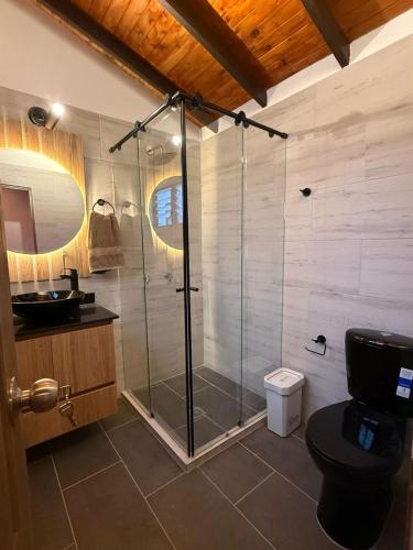 a bathroom with a shower with a toilet and a sink at Nido de Montaña Cabañas in Bello