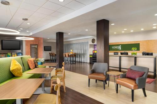 a lobby with tables and chairs and a restaurant at Home2 Suites by Hilton Salt Lake City/Layton in Layton