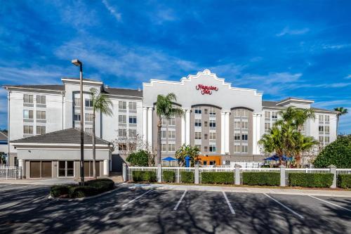 a large white building with a fence in front of it at Hampton Inn Lake Buena Vista / Orlando in Orlando