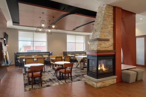 a fireplace in a restaurant with tables and chairs at Hampton Inn Portland Downtown Waterfront in Portland