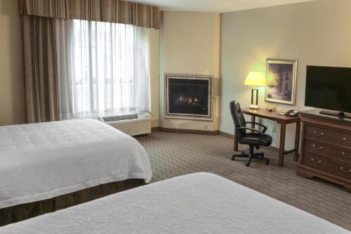 a hotel room with two beds and a desk and a television at Hampton Inn & Suites Youngstown-Canfield in Canfield