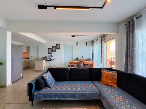 a living room with a blue couch and a kitchen at Beach front luxury living - 2 bedroom condo with sea view in Jan Thiel