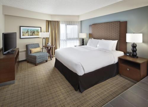 ein Hotelzimmer mit einem großen Bett und einem Fernseher in der Unterkunft DoubleTree by Hilton Hotel & Conference Centre Regina in Regina