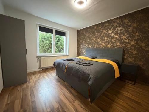 a bedroom with a bed and a wall with flowers at Home4You Hamburg-Neugraben EG in Hamburg