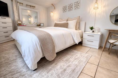 a white bedroom with a large bed and a mirror at Boutique Guest Suite Private Entrance Near Hard Rock FLL Airport Cruise Port in Fort Lauderdale