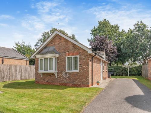 a brick house in a yard with a driveway at Ted's Place in Bridlington