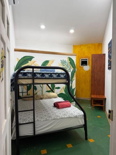 a bedroom with a bunk bed with a green floor at Hotel Tama Lodge in Tamarindo