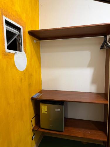 a room with a wooden shelf and a window at Hotel Tama Lodge in Tamarindo