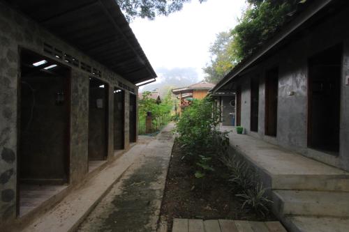 an empty alleyway between two buildings with trees at Chiang Dao Story Camp in Chiang Dao
