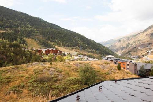 a town on a hill with mountains in the background at Apartaments Les Terrasses del Tarter in El Tarter