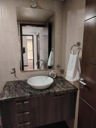 a bathroom with a sink and a large mirror at Departamento de lujo 2D Av Arce in La Paz