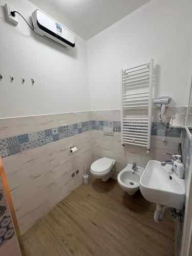a bathroom with a sink and a toilet and a tv at Solaria House in Montesilvano