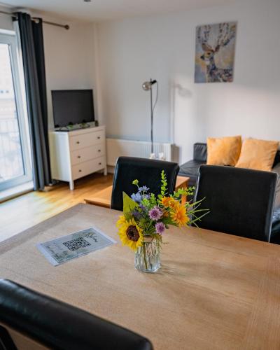 a vase of flowers on a table in a living room at Luxury Penthouse Balcony Flat - 5 Min to Canary Wharf - Prime Long Stays in London