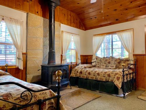 ein Schlafzimmer mit zwei Betten und einem Holzofen in der Unterkunft Rustic Cottages in Tahoe Vista