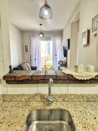 a kitchen counter with a sink in front of a bed at Apê Família | Varanda c/ churrasqueira | Garagem in Ponta Grossa