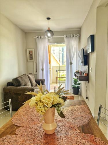 a living room with a vase with flowers on a table at Apê Família | Varanda c/ churrasqueira | Garagem in Ponta Grossa