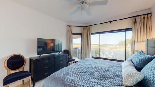 a bedroom with a bed and a dresser and a television at 240 Captains Quarters in Hilton Head Island