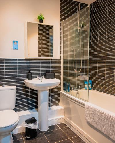 a bathroom with a sink and a toilet and a tub at Luxury Penthouse Balcony Flat - 5 Min to Canary Wharf - Prime Long Stays in London