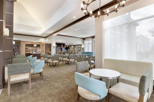 a waiting room with tables and chairs at Hilton Garden Inn Dulles North in Ashburn