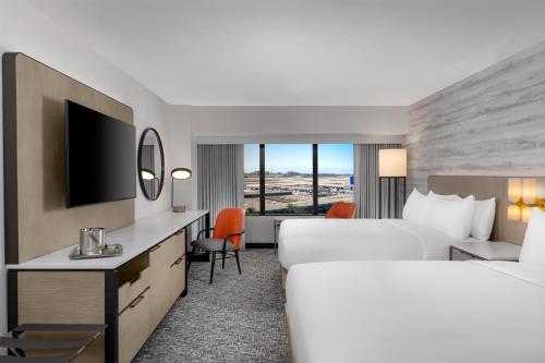a hotel room with two beds and a tv at Hilton Los Angeles Airport in Los Angeles