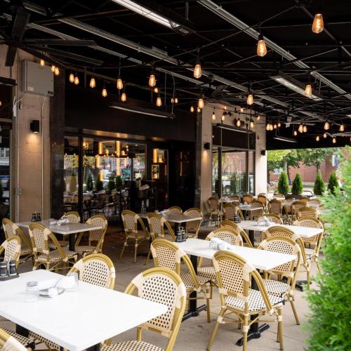 an empty restaurant with white tables and chairs at Hilton Orrington/Evanston in Evanston