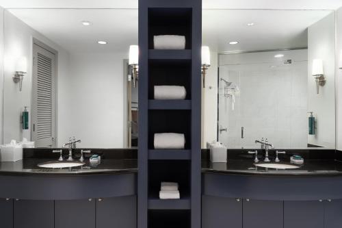a bathroom with two sinks and a large mirror at Hilton Orrington/Evanston in Evanston