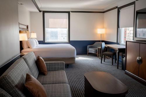 a hotel room with a bed and a couch at Hilton Orrington/Evanston in Evanston