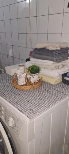 a counter with a pile of towels on top of a washing machine at Ali app in Travnik