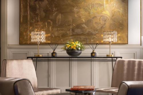 a lobby with two chairs and a table with a painting at Hilton Prague Old Town in Prague