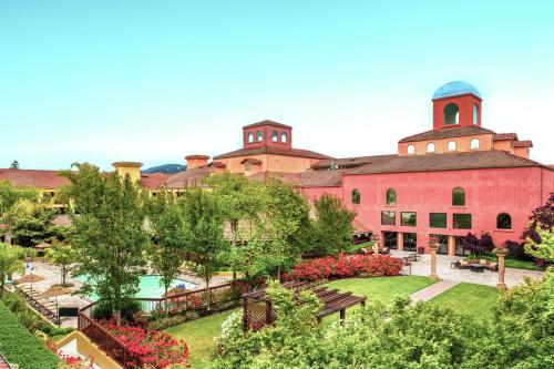 a large red building with a garden in front of it at DoubleTree by Hilton Sonoma Wine Country in Rohnert Park