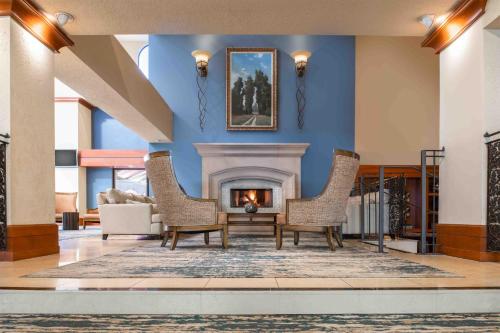 a living room with a fireplace and two chairs at DoubleTree by Hilton Sonoma Wine Country in Rohnert Park
