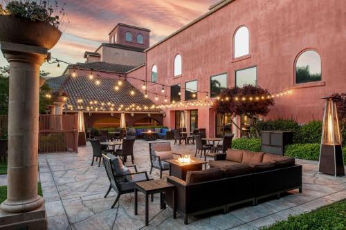 an outdoor patio with tables and chairs and a building at DoubleTree by Hilton Sonoma Wine Country in Rohnert Park
